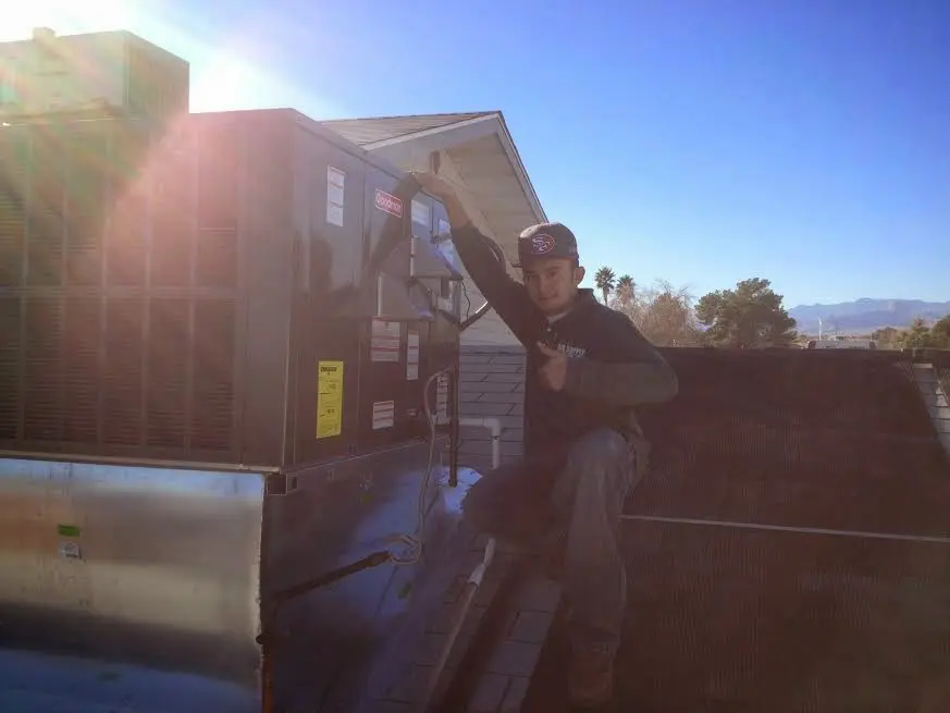 HVAC technician performing AC Tune-Up on a rooftop unit in Mount Vernon